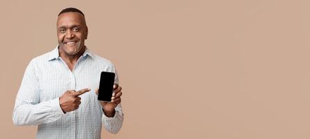 Awesome application or website. Middle aged black man showing blank cellphone screen, orange background with empty space photo