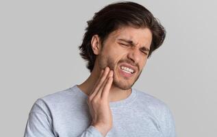 Dental problems concept. Man suffering from bad toothache, empty space photo