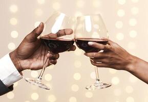 Hands of black man and woman toasting with red wine, restaurant background, cropped photo