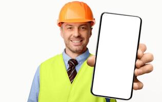 Building Services. Construction Worker Showing Cellphone Empty Screen Smiling To Camera Standing On White Studio Background. Selective Focus, Mockup photo