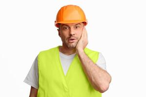 Building Problems. Confused Construction Worker Touching Face Posing Looking At Camera In Shock Over White Studio Background. photo