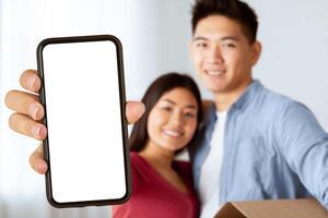 Happy korean family showing keys from their new apartment to camera, selective focus, empty space photo