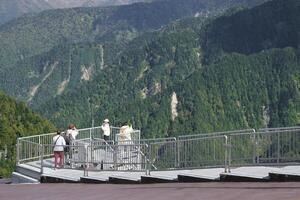 Kurobedaira Station, Tateyama, Toyama, Chubu, Japan, A scenic observation deck with visitors overlooking lush green mountains and valleys photo