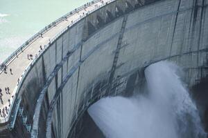 Kurobe Dam, Tateyama, Toyama, Chubu, Japan A large dam with water cascading down photo