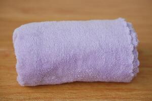 Rolled soft towel isolated on white background. Concept, clothes in daily life using. Towel for bathing, showering or spa massage. photo