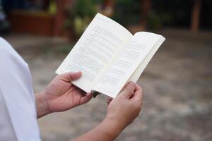 Close up man is reading book. Concept, self study, reading book for knowledge, pleasure or self development to apply knowledge in daily life living. Read for preparing exam. photo