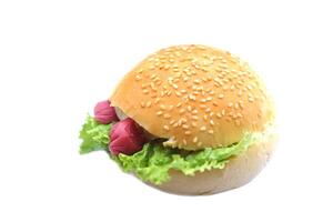 Homemade hamburger stuff with ham, cheese, hot dog and salad vegetables, topping with sesames on bread bun, isolated on white background. Concept delicious fast food. Eating culture for breakfast. photo