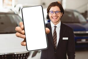 Successful Salesperson. Handsome Agent In Specs Showing Auto Key Standing In Automobile Rental Office, Free Space photo
