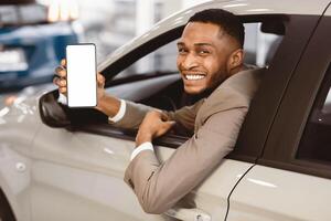 Afro Businessman Showing Car Key Sitting In Driver's Seat Smiling To Camera Buying Auto In Dealership Store. Selective Focus photo