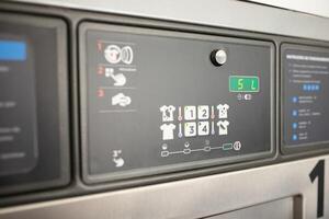 The control panel of a washing machine displays various options for different wash cycles and settings. Users can select from multiple programs and adjust load sizes easily. photo