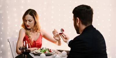 She Said No. Young Woman Refusing Marriage Proposal From Boyfriend, Gesturing Stop To Offered Engagement Ring On Date In Restaurant, Selective Focus photo