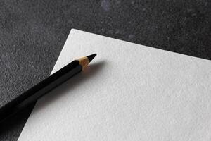 Paper mockup. Watercolor A4 paper with black pencil on dark background. photo