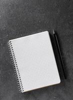 Notebook mockup. A5 paper with black pencil on dark background. photo