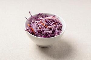 Fresh red cabbage salad. Healthy and delicious vegetarian food in a white bowl. photo