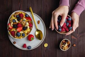 Corn flakes with berries and nuts in bowl photo