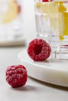 Raspberry cocktail with ice in a glass on a light background photo