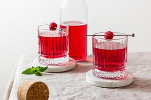 Raspberry cocktail in a glass on a marble stand photo