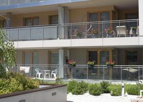 Beautiful European balcony with flowers and a swing chair on it in an apartment building photo