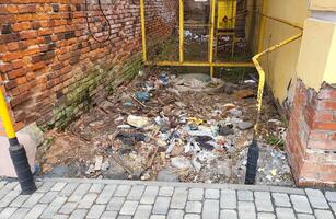 The walls of a brick house. Garbage is lying between the houses. photo