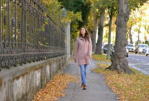 A girl walks along a calm and quiet street on a sunny autumn day in Vienna photo