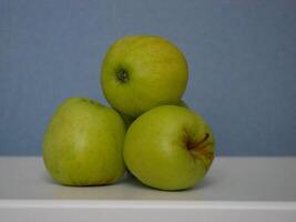 Golden Delicious apples at a blue background photo