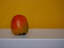 Persimmon Diospyros Kaki fruit at yellow background photo