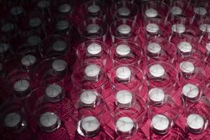 Candles in glasses. Lots of candles on table. Texture of transparent cups. photo