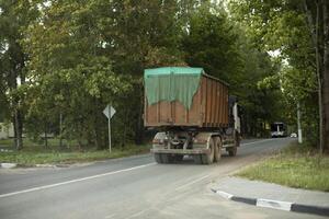 Garbage truck. Transportation of waste in summer. Truck on road. Large container of garbage. photo