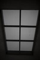 Large window in the ceiling. Faint light through glass. Grey day outside the window. photo