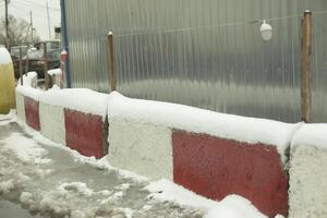 Fence in winter. Concrete blocks around the construction site. Winter construction. photo