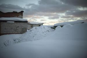 Snow heap in Narazh. A large snowdrift. Garages in winter. photo