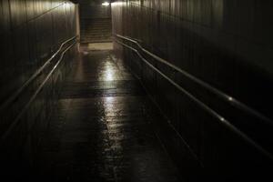 Light in the tunnel. Cycling descent into the tunnel. Wet pedestrian crossing. photo