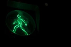 Green Pedestrian Crossing Sign. The Green Man on the Sphetophore. Figure of a man made of light bulbs. photo