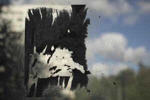 Trace of announcement on glass. Torn pieces of paper on surface. Fragments of announcement. photo