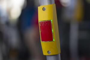 Stop button on the handrail on the bus. Signal button in transport. Emergency braking. photo