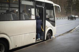 People get on bus. Person gets into transport. photo