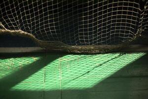 Light through grid. Light in gym. Shadow on floor. photo