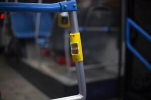 Stop button on the bus. Interior of public transport. Stop button on handrail. photo