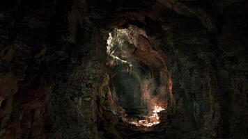 Exploring an ancient cave illuminated by natural light in a remote wilderness video