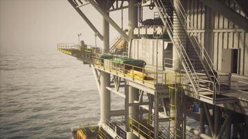 Old oil platform standing off the coast during hazy daylight hours video