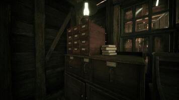 Old wooden desk with drawers and books under warm light in a rustic room video