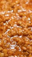 Close-up of meat stewed in sauce. Concept. Minced meat is well fried in large amount of sauce in pan. Professional cooking of minced meat gravy with sauce video