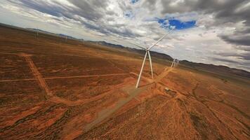 A wind turbine rotates in a field in Australia, drone . video