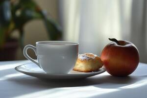 A cup of coffee and an apple on a table photo