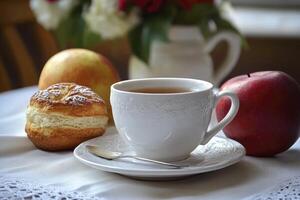 A cup of tea and a pastry on a table photo
