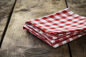 A stack of red and white checkered napkins on a wooden table photo