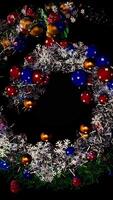 Abstract beautiful spiral, Christmas garland with toys and tinsel, seamless loop. Animation. Spinning silver and green vortex with colorful New Year tree decorations on black background. video