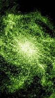 Green illuminated particles in a form of giant field in fast motion. Animation. Abstract glowing field with energy epicenter that spreading rays of light on black background, seamless loop. video