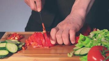Chef in Black Uniform is Slicing Red Paprika and Preparing Vegetable Ingredients for Cooking. Man in a Kitchen is Cutting Red Pepper for Vegetarian Dish. Healthy Food Concept video