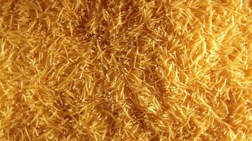 Background of Uncooked Golden Noodles that Rotating Counterclockwise - Top View. Texture of Dry Vermicelli Turning Around. Raw Pasta with Low Key Light - Left Rotation video